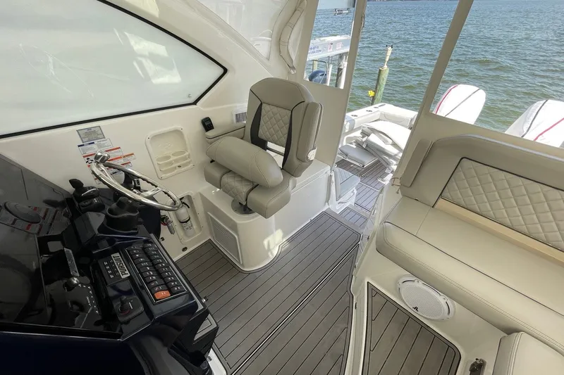 Slide: The Image of 2022 Pursuit OS 355 Offshore boat interior with helm, seating, and ocean view. - 24