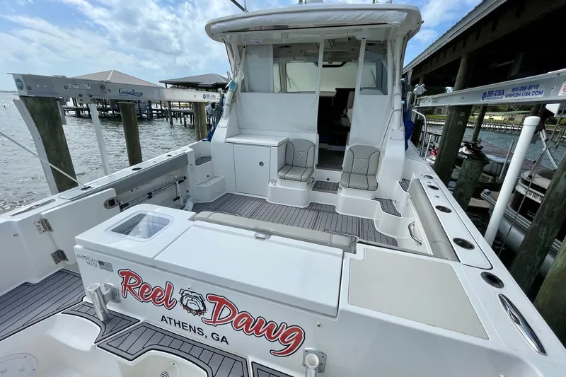 Slide: The Image of 2022 Pursuit OS 355 Offshore boat docked, featuring spacious seating and fishing amenities. - 8