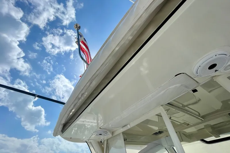 Slide: The Image of 2022 Pursuit OS 355 Offshore boat with American flag against a blue sky. - 17