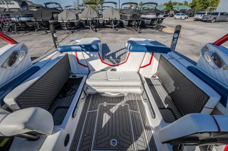 Slide: The Image of 2016 Nautique Super Air Nautique G23 interior with seating and storage, parked among covered boats. - 32