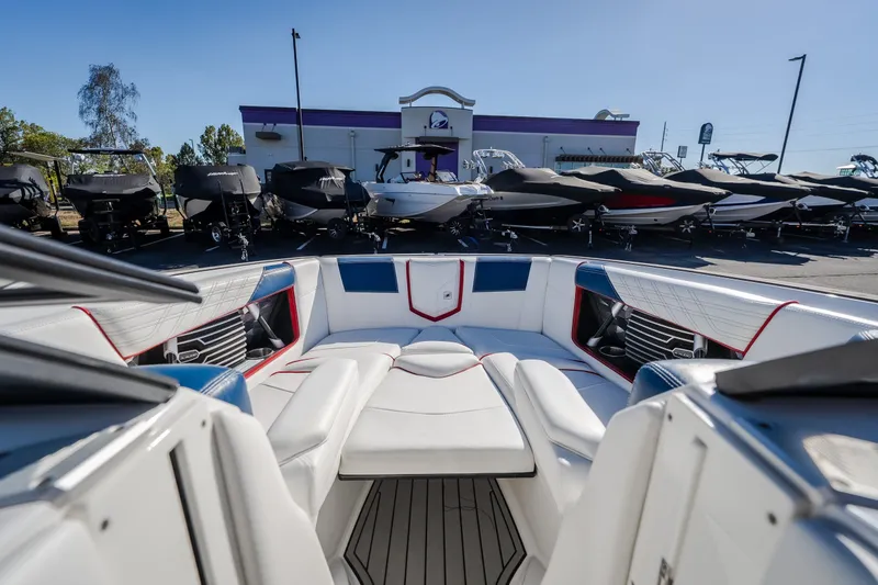 Slide: The Image of 2016 Nautique Super Air Nautique G23 boat interior with luxurious seating, displayed outdoors. - 21