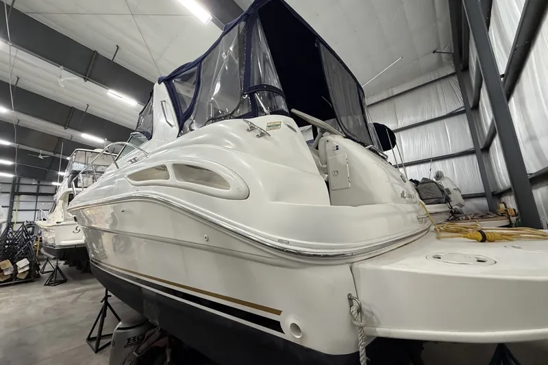 Slide: The Image of 1999 Sea Ray 340 Sundancer yacht in indoor storage, showcasing sleek design and covered cockpit. - 10
