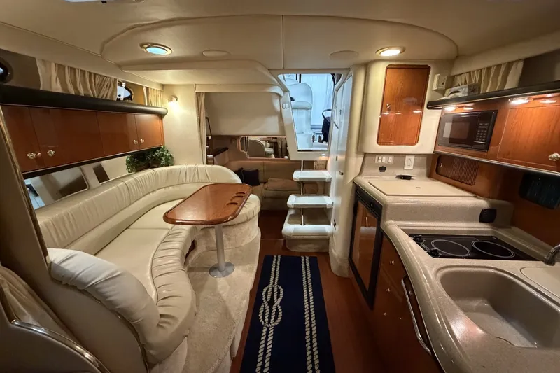Slide: The Image of Luxurious interior of a 1999 Sea Ray 340 Sundancer yacht with kitchen and seating area. - 25