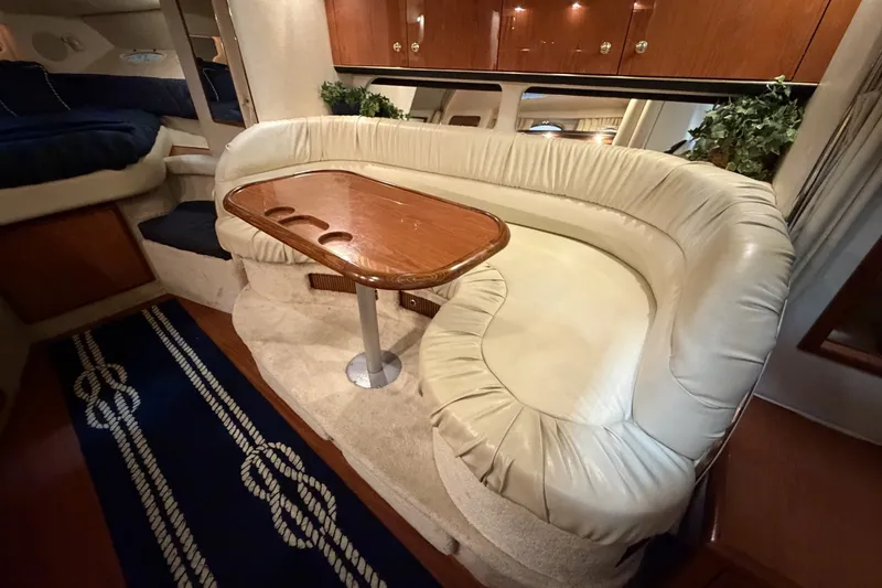 Slide: The Image of Luxurious interior of 1999 Sea Ray 340 Sundancer with plush seating and elegant wooden table. - 33