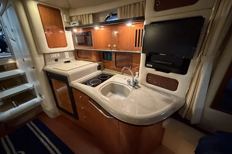 Slide: The Image of 1999 Sea Ray 340 Sundancer yacht interior with kitchenette, sink, and microwave. - 30