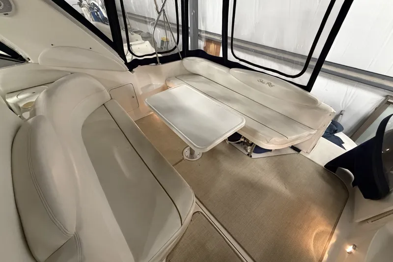 Slide: The Image of 1999 Sea Ray 340 Sundancer interior with white seating and table in a spacious cabin. - 14