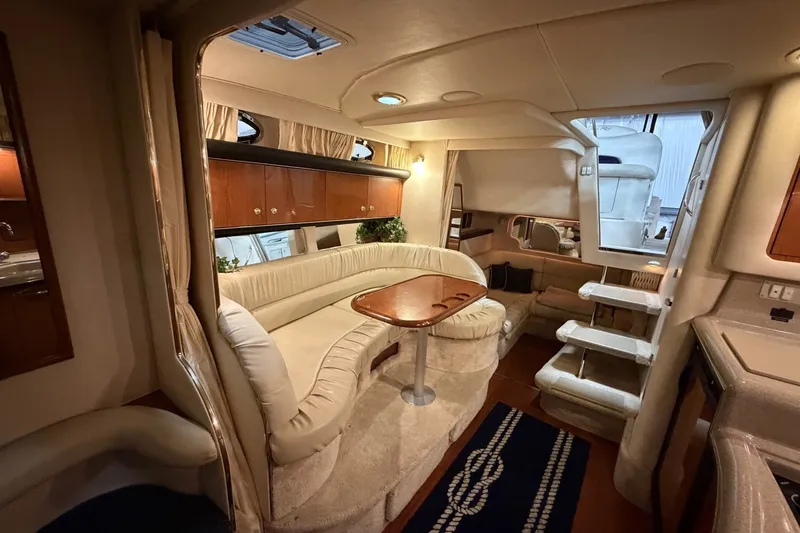 Slide: The Image of Interior of a 1999 Sea Ray 340 Sundancer yacht, featuring a cozy seating area and elegant design. - 32