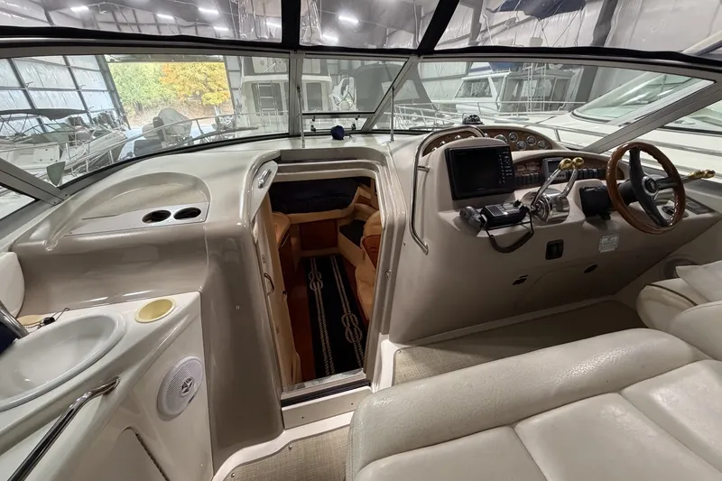 Slide: The Image of 1999 Sea Ray 340 Sundancer cockpit with steering wheel, navigation equipment, and cabin entrance. - 20