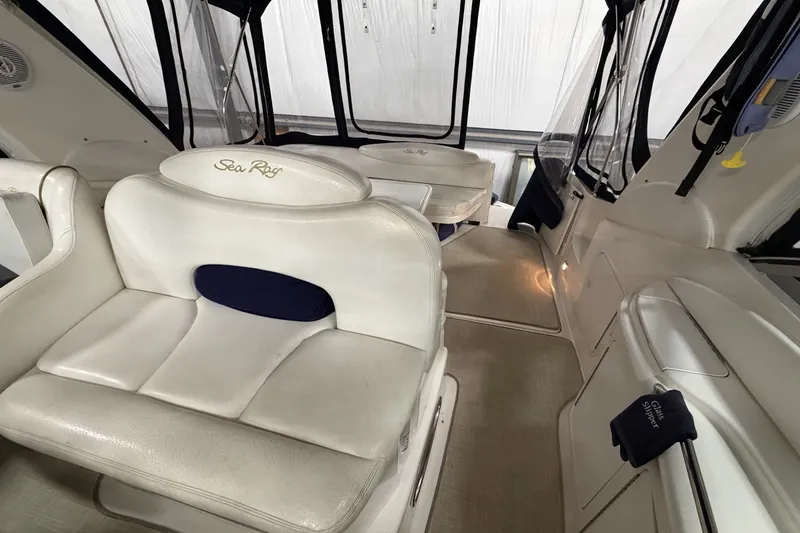 Slide: The Image of Interior of a 1999 Sea Ray 340 Sundancer boat with white seating and carpeted floor. - 22
