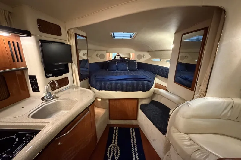 Slide: The Image of Luxurious interior of a 1999 Sea Ray 340 Sundancer yacht with cozy bed and kitchenette. - 27