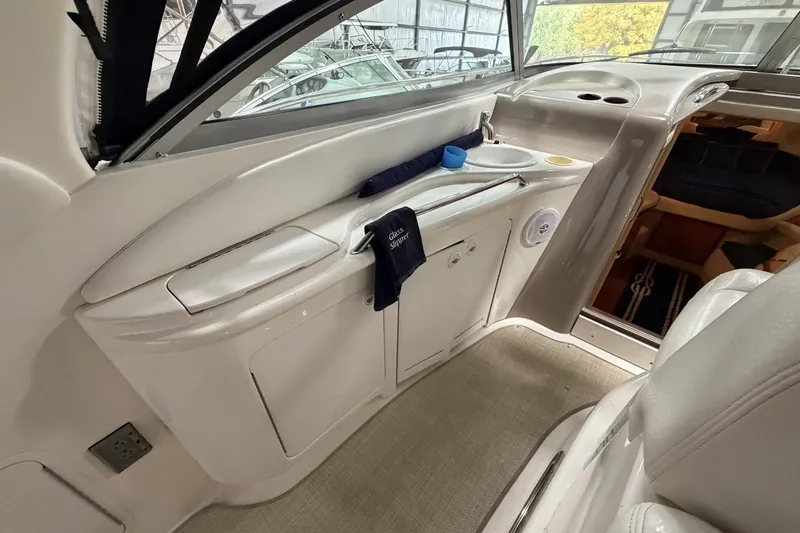 Slide: The Image of Interior of 1999 Sea Ray 340 Sundancer yacht, featuring sleek white cabinetry and seating. - 17