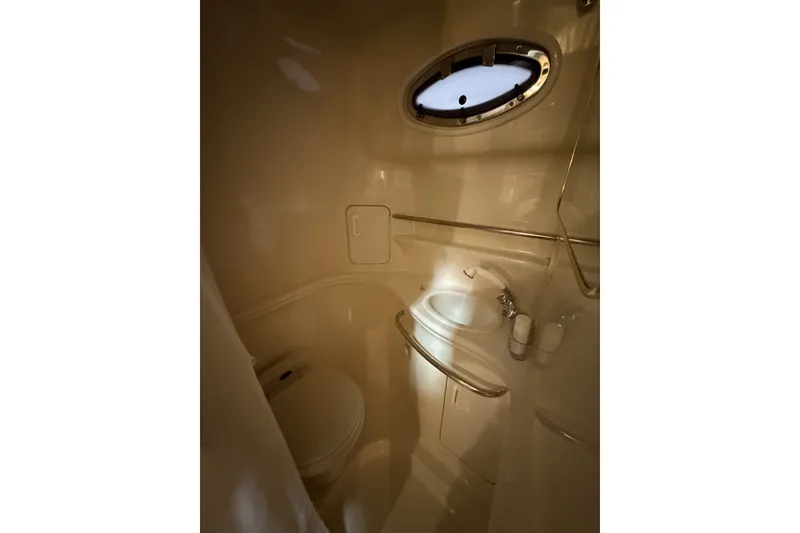 Slide: The Image of Bathroom interior of 1999 Sea Ray 340 Sundancer yacht, featuring sink and porthole window. - 38
