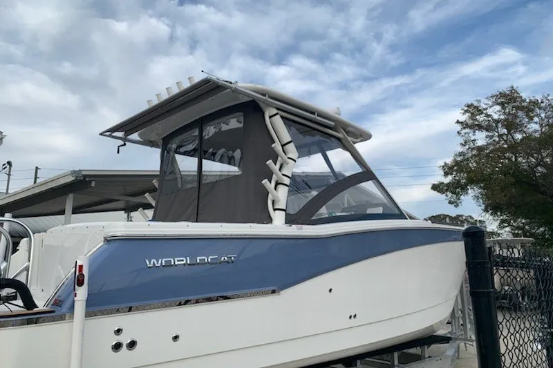 Slide: The Image of 2021 World Cat 280 DC-X boat with blue and white exterior, docked under cloudy sky. - 25