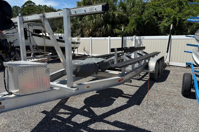 Slide: The Image of Boat trailer for 2021 World Cat 280 DC-X, parked outdoors on gravel. - 24