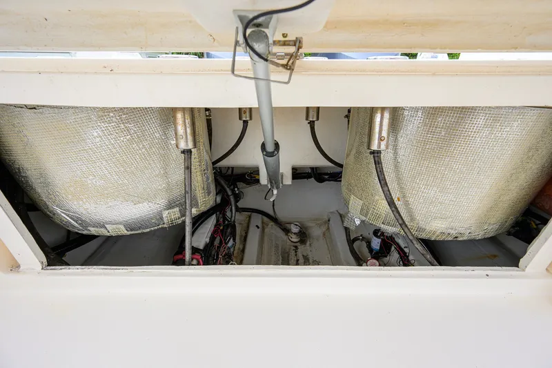 Slide: The Image of 2019 Cobia 301 Center Console boat storage compartment with insulated tanks and wiring. - 25