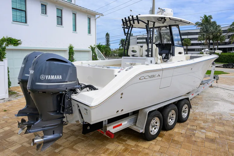 Slide: The Image of 2019 Cobia 301 Center Console boat on trailer with dual Yamaha engines. - 7