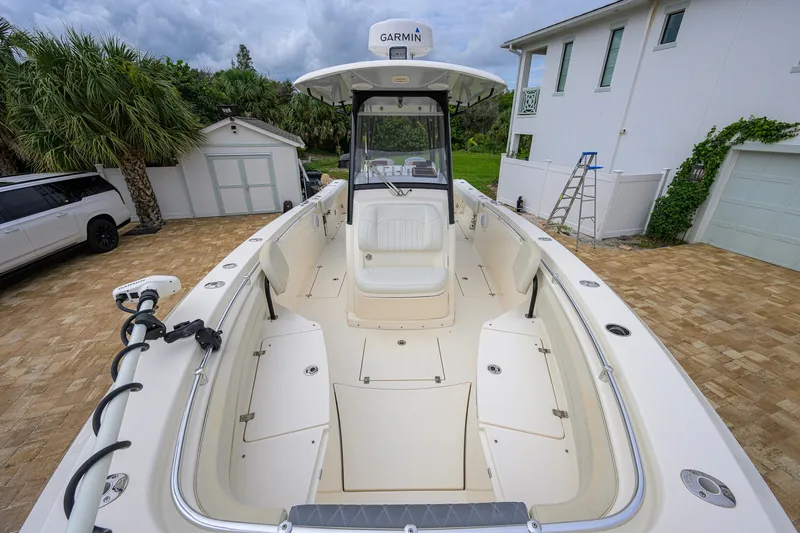 Slide: The Image of 2019 Cobia 301 Center Console boat parked on a brick driveway near a house. - 42