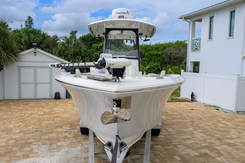 Slide: The Image of 2019 Cobia 301 Center Console boat parked on a paved driveway. - 10