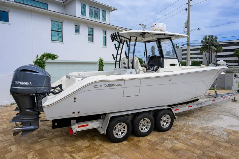 The Image of 2019 Cobia 301 Center Console boat on trailer, featuring Yamaha outboard motor. - 0