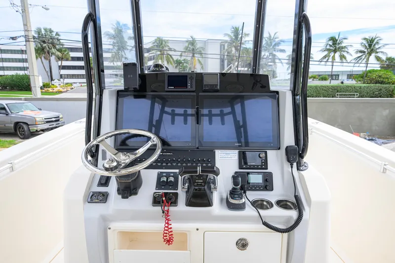 Slide: The Image of 2019 Cobia 301 Center Console boat dashboard with steering wheel and navigation controls. - 34