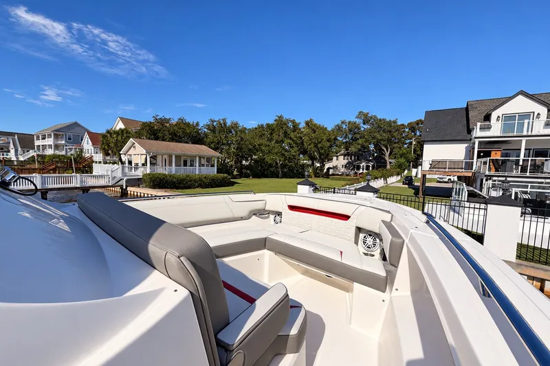 Slide: The Image of 2023 Tiara Yachts 34 LS boat interior with luxurious seating, docked near waterfront homes. - 14