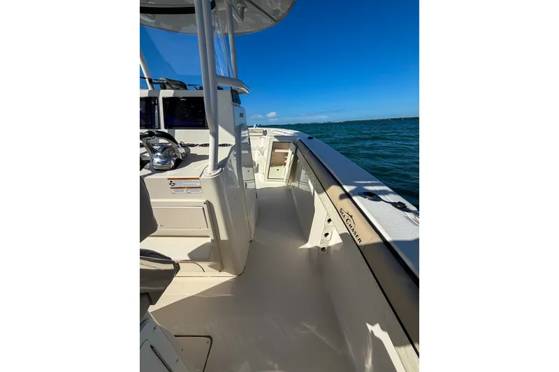 Slide: The Image of 2021 Sea Chaser 30 HFC CC boat on water, showcasing deck and steering area. - 12