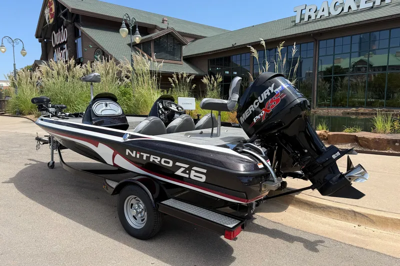 Slide: The Image of 2014 Nitro Z-6 boat with Mercury Pro XS engine parked outside a store. - 2