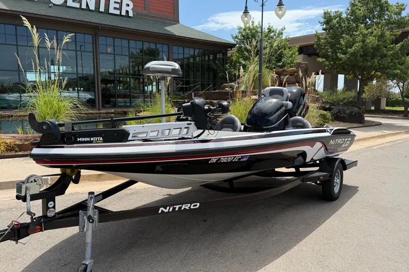 Slide: The Image of 2014 Nitro Z-6 boat with Minn Kota motor on trailer, parked outside a building. - 3