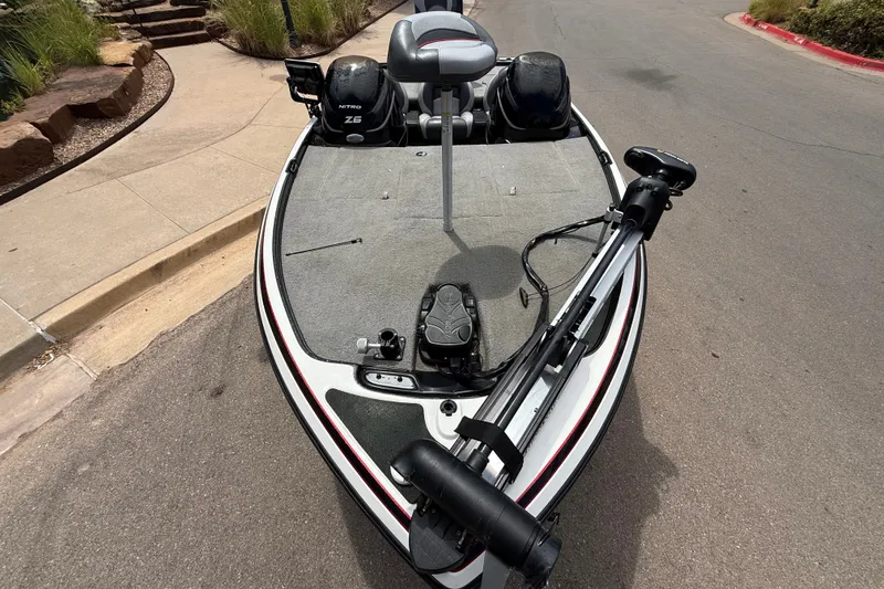Slide: The Image of 2014 Nitro Z-6 fishing boat parked on a street, featuring trolling motor and seating. - 5