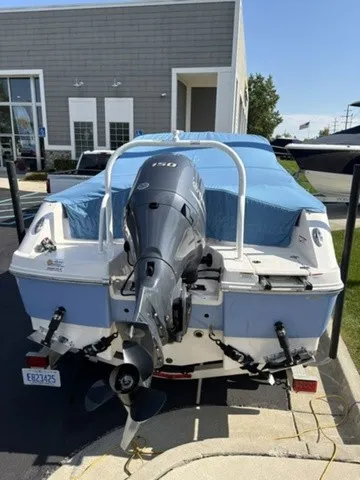 Slide: The Image of A 2023 Robalo R207 Dual Console boat with an outboard motor, covered and on a trailer. - 6
