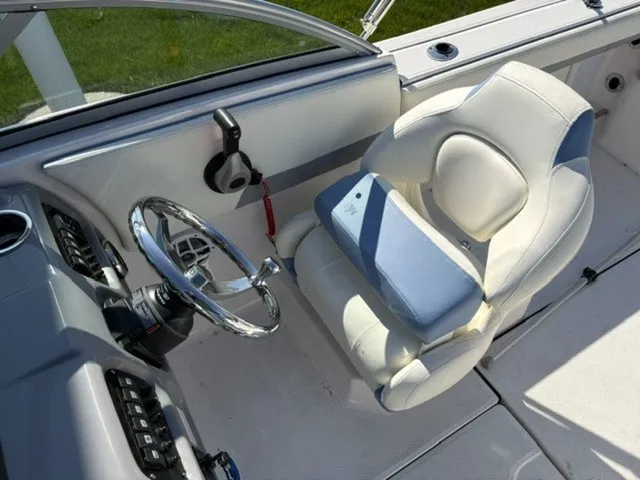 Slide: The Image of The image shows the helm of a Robalo R207 Dual Console boat with a comfortable white seat. - 18