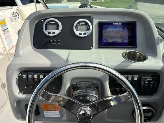 Slide: The Image of The image shows the dashboard of a Robalo R207 Dual Console boat with steering wheel, gauges, and a Simrad display. - 14