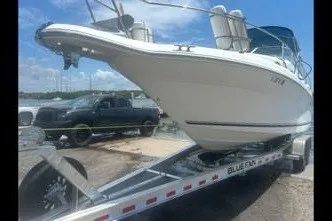 The Image of 1996 Sea Ray 270 Sundancer boat on trailer, parked outdoors under blue sky. - 0