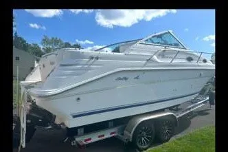Slide: The Image of 1996 Sea Ray 270 Sundancer boat on trailer under a clear blue sky. - 1