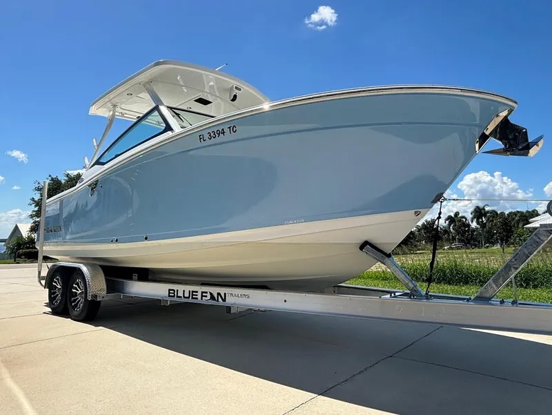 Slide: The Image of 2021 Blackfin 272 DC boat on trailer under sunny skies. - 1