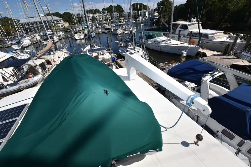 Slide: The Image of 1989 Jefferson Marquessa 52 yacht docked at marina, covered with green tarp. - 37