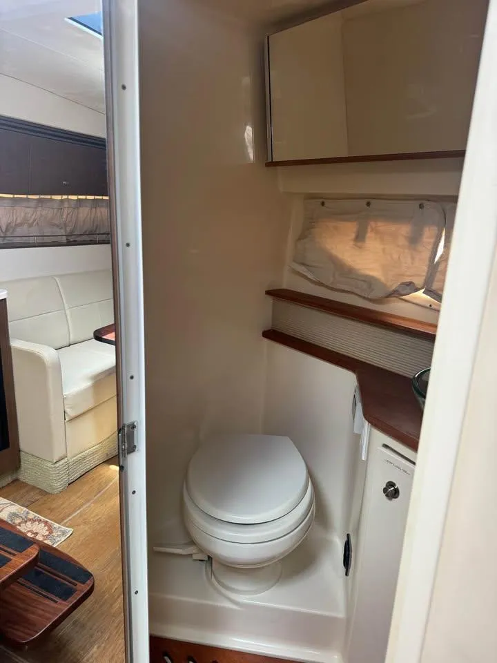 Slide: The Image of 2017 Sea Ray Sundancer 350 Coupe bathroom interior with toilet and wooden accents. - 16