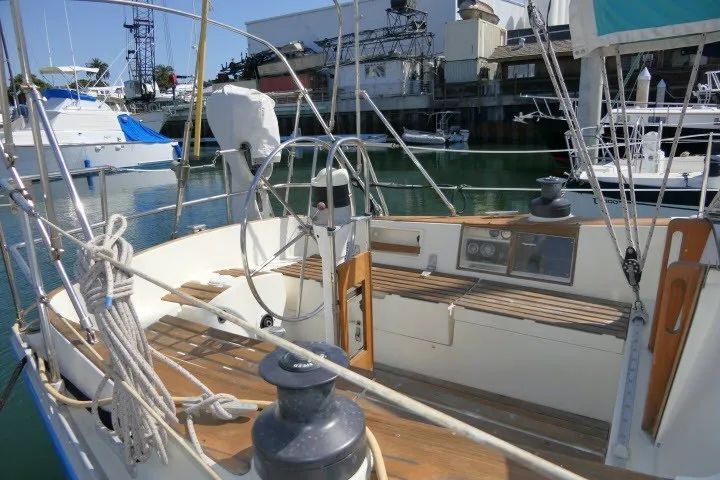 Slide: The Image of 1984 Wauqueize Hood 38 MK II sailboat cockpit with steering wheel and marina background. - 31