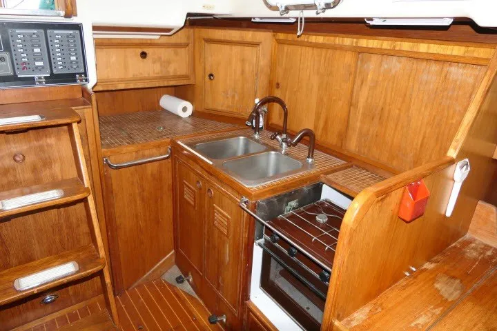Slide: The Image of 1984 Wauqueize Hood 38 MK II yacht kitchen with wooden cabinetry and dual sink. - 19