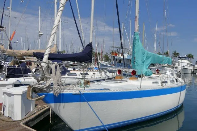 Slide: The Image of 1984 Wauqueize Hood 38 MK II sailboat docked in marina, blue stripe, covered sails. - 56