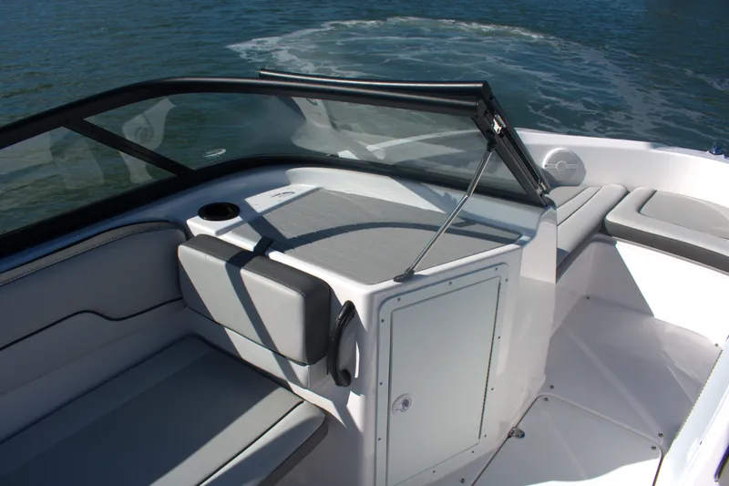 Slide: The Image of 2025 Yamaha Boats AR190 interior with seating and windshield, on calm water. - 11