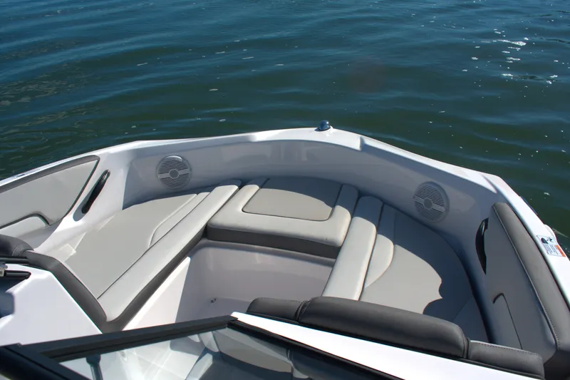 Slide: The Image of 2025 Yamaha Boats AR190 bow seating area with speakers on calm water. - 5