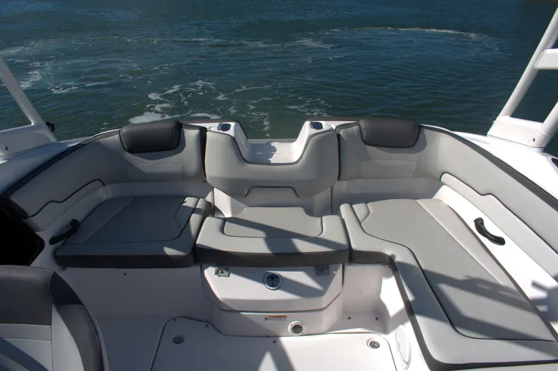 Slide: The Image of 2025 Yamaha Boats AR190 interior seating with gray upholstery on calm water. - 17