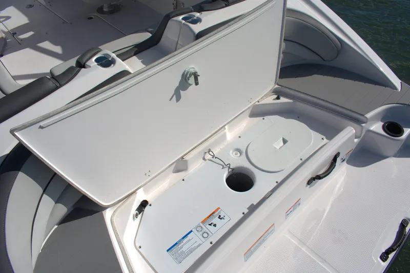 Slide: The Image of 2025 Yamaha Boats AR190 storage compartment with open hatch, showcasing interior features. - 20