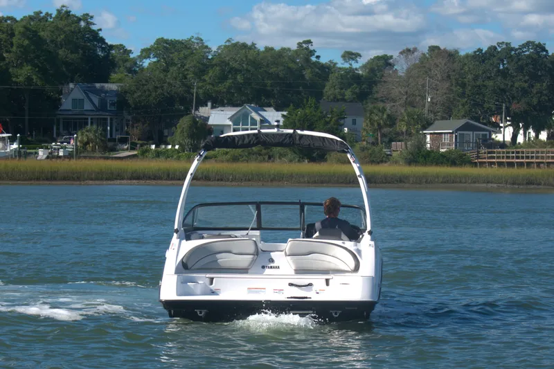 Slide: The Image of 2025 Yamaha Boats AR190 cruising on a scenic waterway with lush greenery. - 3