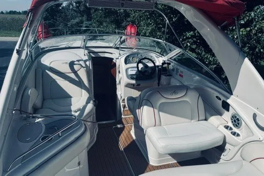 Slide: The Image of 2004 Monterey 298SC Super Sport boat interior with white seating and steering console. - 2