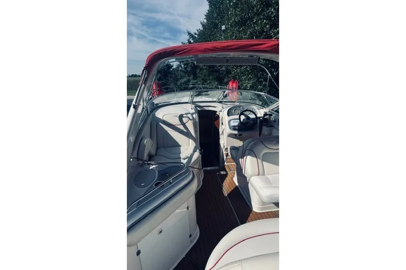 Slide: The Image of Interior of a 2004 Monterey 298SC Super Sport boat with red canopy and white seating. - 6