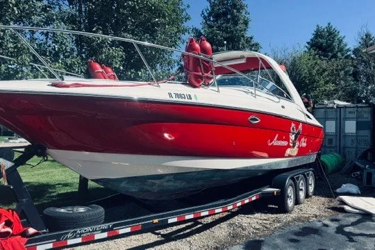 The Image of Red 2004 Monterey 298SC Super Sport boat on trailer, parked outdoors. - 0