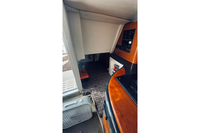 Slide: The Image of Interior cabin of a 2004 Monterey 298SC Super Sport boat, featuring wood paneling and carpet. - 10