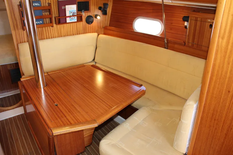 Slide: The Image of Interior of 2003 Dufour Gib Sea 37 sailboat with wooden dining table and beige seating. - 28